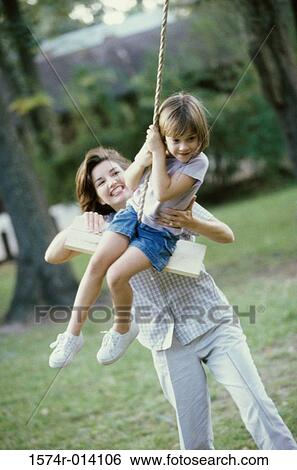 Stock Photograph - Mother pulling her daughter on a rope swing. Fotosearch