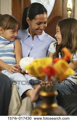 Mother sitting with her two daughters smiling View Large Photo Image Stock Image - Mother sitting with her two daughters smiling. Fotosearch