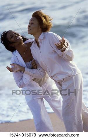 Stock Photo - Mother walking with her daughter on the beach. Fotosearch
