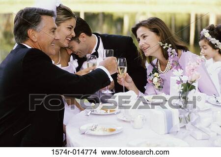 Picture - Newlywed couple and their parents at a table. Fotosearch