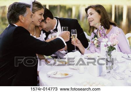 Stock Image - Newlywed couple and their parents at a table. Fotosearch