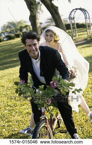 Newlywed couple riding a bicycle View Large Photo Image Stock Photograph - Newlywed couple riding a bicycle. Fotosearch