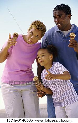Stock Image - Parents and their daughter holding ice cream cones. Fotosearch