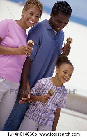 Parents and their daughter holding ice cream cones and smiling View Large Photo Image Stock Image - Parents and their daughter holding ice cream cones and smiling. Fotosearch