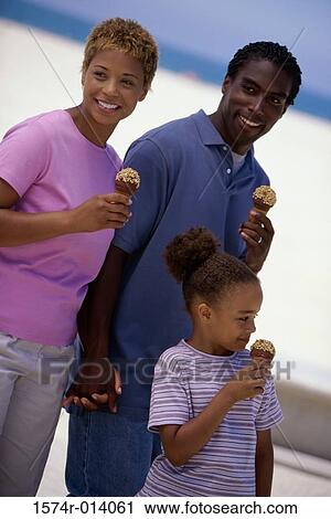 Parents and their daughter holding ice cream cones and smiling View Large Photo Image Stock Image - Parents and their daughter holding ice cream cones and smiling. Fotosearch