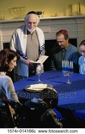 Stock Image - Parents and their son and a rabbi at a Hanukkah ceremony. Fotosearch