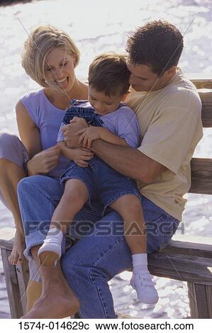 Parents and their son sitting on a bench View Large Photo Image Stock Image - Parents and their son sitting on a bench. Fotosearch