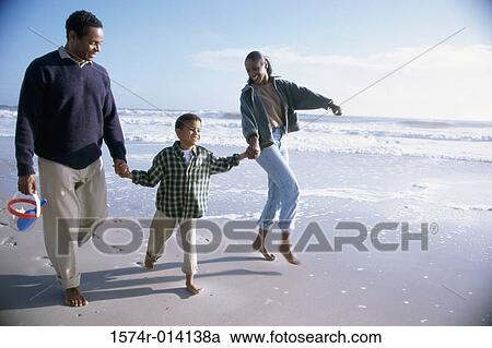 Parents and their son walking on the beach View Large Photo Image Stock Image - Parents and their son walking on the beach. Fotosearch