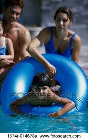 Parents and their two children playing in a swimming pool View Large Photo Image Stock Image - Parents and their two children playing in a swimming pool. Fotosearch