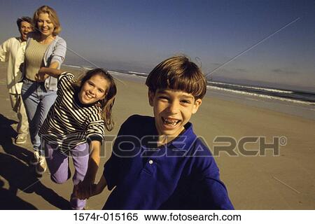 Parents and their two children running on the beach View Large Photo Image Stock Photography - Parents and their two children running on the beach. Fotosearch