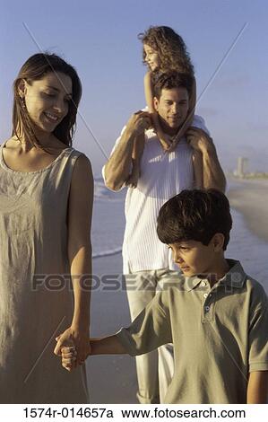 Parents and their two children walking on the beach View Large Photo Image Stock Image - Parents and their two children walking on the beach. Fotosearch