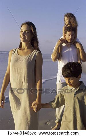 Parents and their two children walking on the beach View Large Photo Image Stock Image - Parents and their two children walking on the beach. Fotosearch