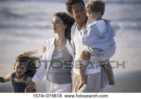 Parents and their two children walking on the beach View Large Photo Image Stock Photo - Parents and their two children walking on the beach. Fotosearch