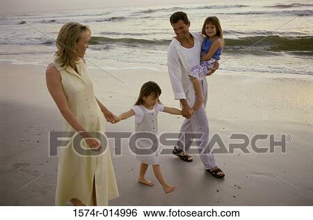 Parents and their two daughters walking on the beach View Large Photo Image Stock Photograph - Parents and their two daughters walking on the beach. Fotosearch