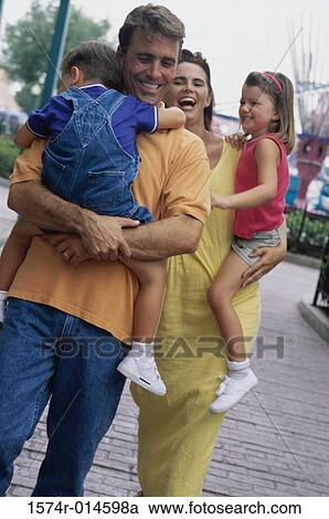 Stock Image - Parents carrying their son and daughter. Fotosearch