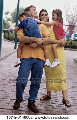Stock Image - Parents carrying their son and daughter. Fotosearch