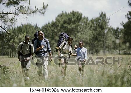 Stock Image - Parents hiking with their son and daughter in a field. Fotosearch