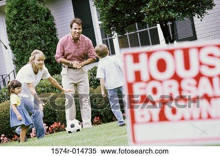 Stock Photography - Parents playing with their two children on a lawn. Fotosearch