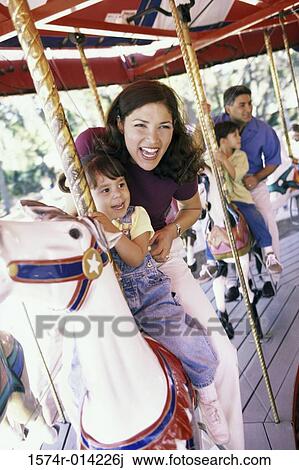 Parents sitting on a carousel with their son and daughter View Large Photo Image Stock Image - Parents sitting on a carousel with their son and daughter. Fotosearch