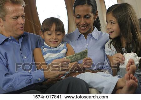 Parents sitting with their two daughters looking at money View Large Photo Image Stock Image - Parents sitting with their two daughters looking at money. Fotosearch
