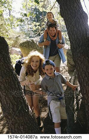 Parents with their son and daughter walking in a forest View Large Photo Image Stock Image - Parents with their son and daughter walking in a forest. Fotosearch