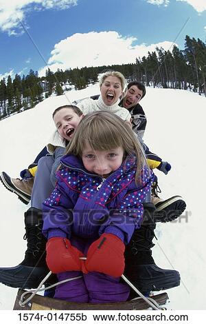 Parents with their son and daughter sliding down a hill on a toboggan View Large Photo Image Stock Image - Parents with their son and daughter sliding down a hill on a toboggan. Fotosearch