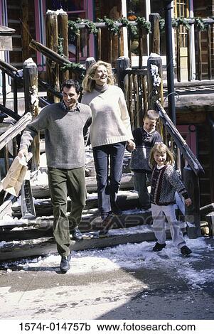 Stock Image - Parents with their son and daughter walking down stairs. Fotosearch