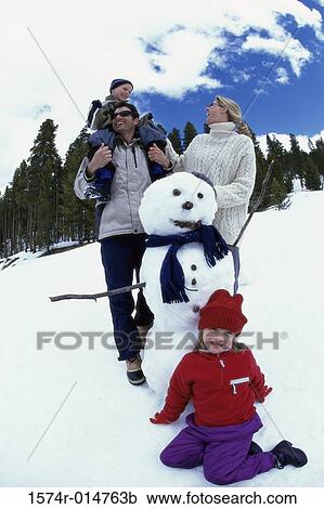 Parents with their son and daughter near a snowman View Large Photo Image Stock Image - Parents with their son and daughter near a snowman. Fotosearch