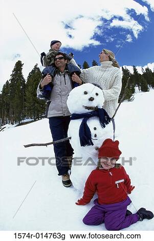 Parents with their son and daughter near a snowman View Large Photo Image Stock Image - Parents with their son and daughter near a snowman. Fotosearch