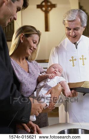 Stock Image - Parents with their son at a baptism. Fotosearch