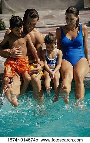 Parents with their two children sitting at the poolside View Large Photo Image Stock Image - Parents with their two children sitting at the poolside. Fotosearch