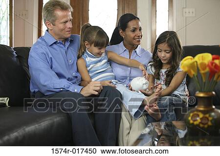 Parents with their two daughters sitting on a couch View Large Photo Image Stock Image - Parents with their two daughters sitting on a couch. Fotosearch