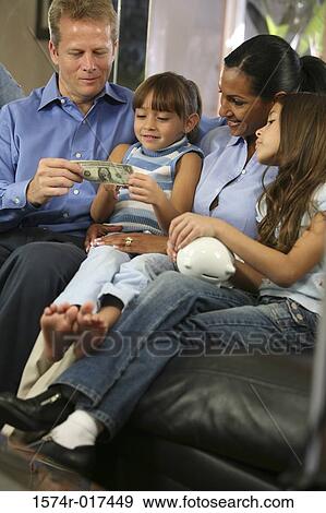 Stock Photo - Parents with their two daughters looking at money. Fotosearch