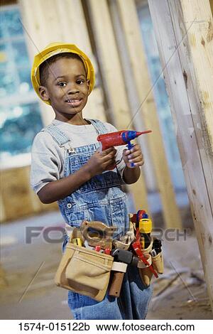Portrait of a boy dressed as a construction worker holding a toy drill View Large Photo Image Stock Image - Portrait of a boy dressed as a construction worker holding a toy drill. Fotosearch