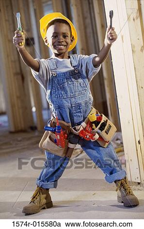Portrait of a boy dressed as a construction worker holding two toy screwdrivers View Large Photo Image Stock Image - Portrait of a boy dressed as a construction worker holding two toy screwdrivers. Fotosearch