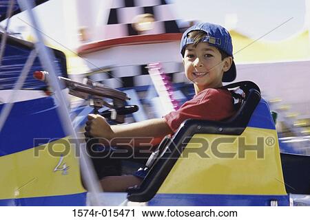Stock Image - Portrait of a boy sitting on an amusement park ride. Fotosearch