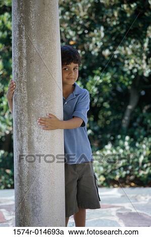 Portrait of a boy standing behind a column View Large Photo Image Stock Image - Portrait of a boy standing behind a column. Fotosearch