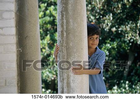 Portrait of a boy standing behind a column View Large Photo Image Stock Image - Portrait of a boy standing behind a column. Fotosearch