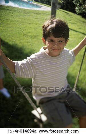 Portrait of a boy swinging on a rope swing View Large Photo Image Stock Image - Portrait of a boy swinging on a rope swing. Fotosearch