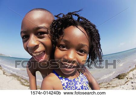 Stock Image - Portrait of a brother and sister on the beach. Fotosearch