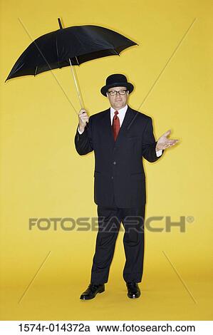 Portrait of a businessman holding an umbrella View Large Photo Image Stock Image - Portrait of a businessman holding an umbrella. Fotosearch