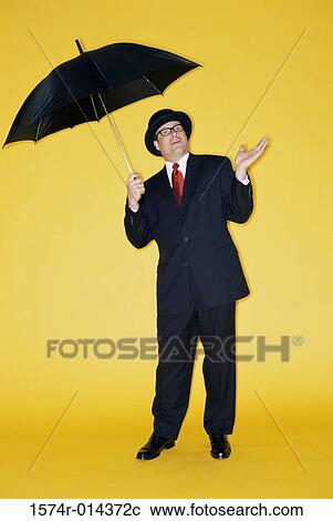 Portrait of a businessman holding an umbrella View Large Photo Image Stock Image - Portrait of a businessman holding an umbrella. Fotosearch