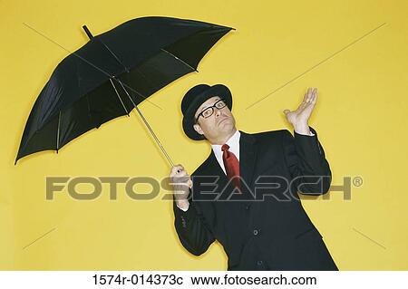 Portrait of a businessman holding an umbrella View Large Photo Image Stock Image - Portrait of a businessman holding an umbrella. Fotosearch