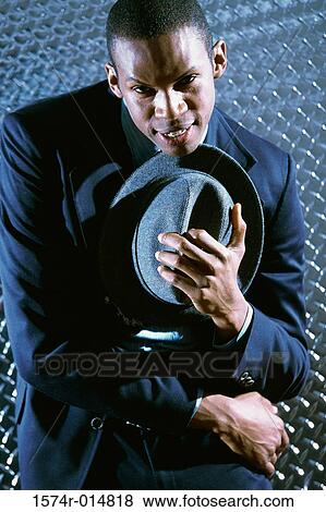 Stock Photo - Portrait of a businessman holding his hat. Fotosearch
