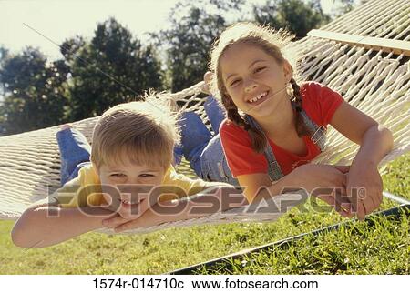 Portrait of a girl and a boy lying in a hammock View Large Photo Image Stock Image - Portrait of a girl and a boy lying in a hammock. Fotosearch