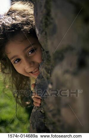 Portrait of a girl hiding behind a rock View Large Photo Image Stock Image - Portrait of a girl hiding behind a rock. Fotosearch
