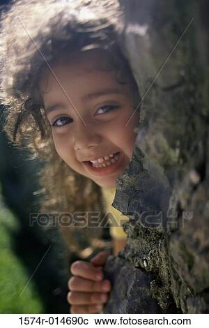 Portrait of a girl hiding behind a rock View Large Photo Image Stock Image - Portrait of a girl hiding behind a rock. Fotosearch