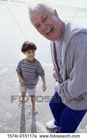 Portrait of a grandfather laughing with his grandson on the beach View Large Photo Image Stock Image - Portrait of a grandfather laughing with his grandson on the beach. Fotosearch