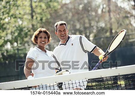 Portrait of a mid adult couple playing tennis View Large Photo Image Stock Image - Portrait of a mid adult couple playing tennis. Fotosearch