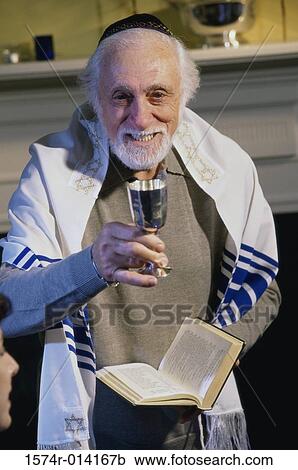 Portrait of a rabbi holding a goblet and a bible at a Hanukkah ceremony View Large Photo Image Stock Image - Portrait of a rabbi holding a goblet and a bible at a Hanukkah ceremony. Fotosearch